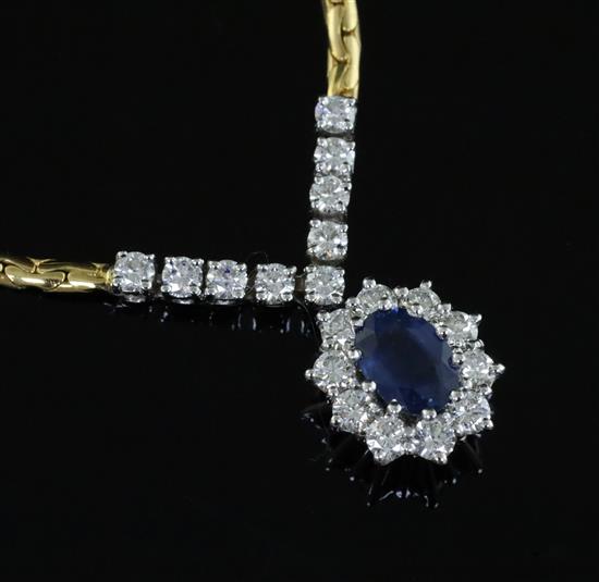 An 18ct two colour gold, sapphire and diamond oval cluster pendant necklace, 42cm